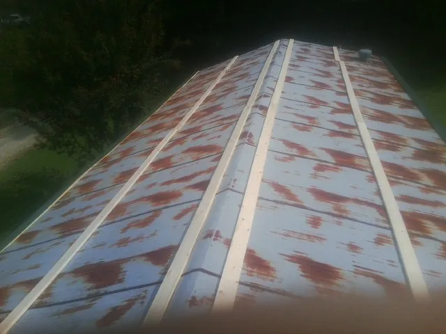 Rusted metal roof panels with new wood purlins before replacement — Storm Damage Roof Repair in Tomkins Cove by Roofing Brothers
