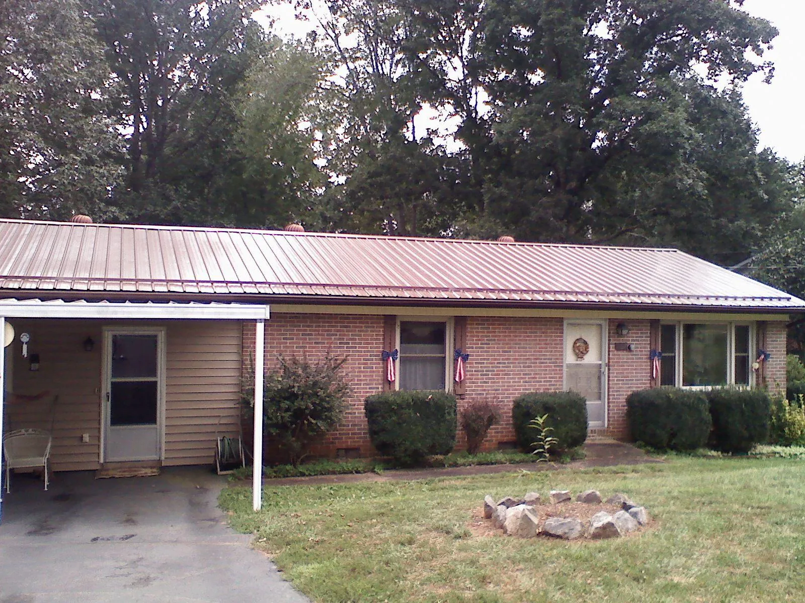 Bronze metal roof and carport on a brick ranch home — Roof Repair work by our crew in Tomkins Cove
